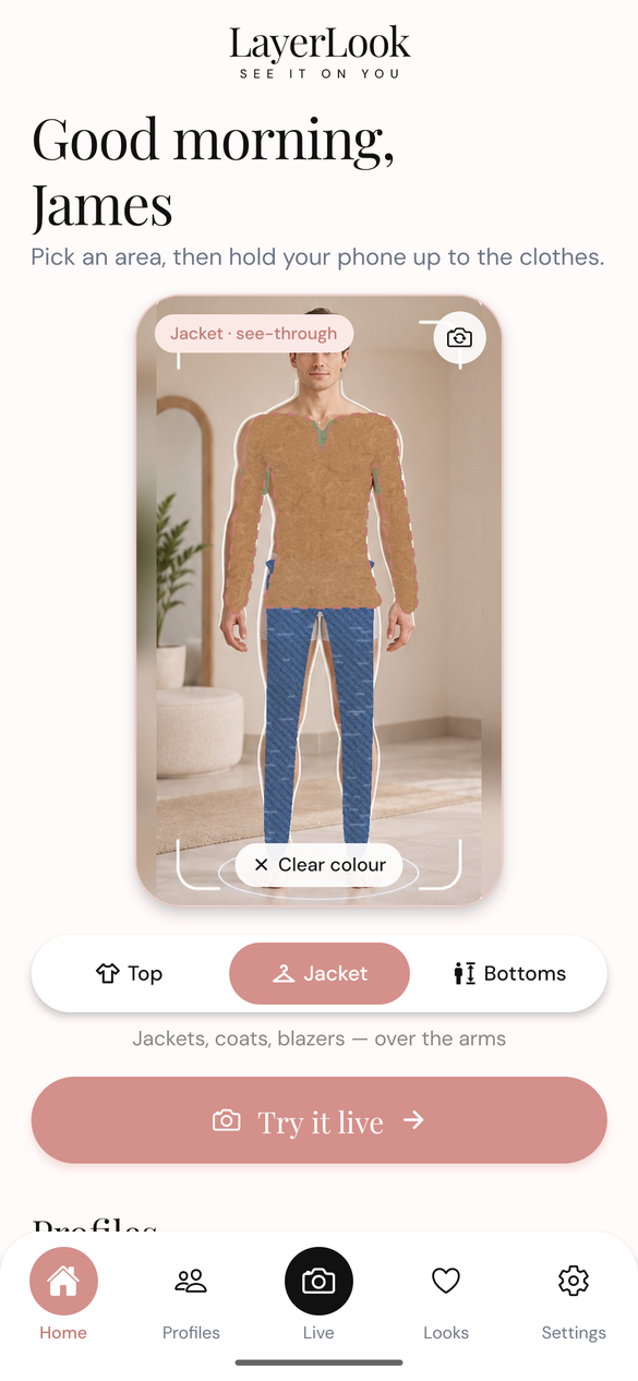 A camel jacket layered over a sage top and denim jeans on a man's profile photo
